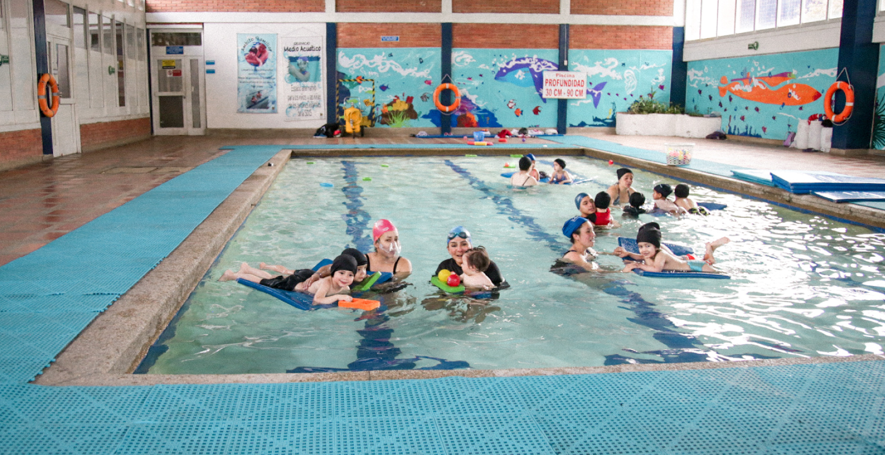 Mujeres y sus hijos en servicios de piscina en manzana del cuidado