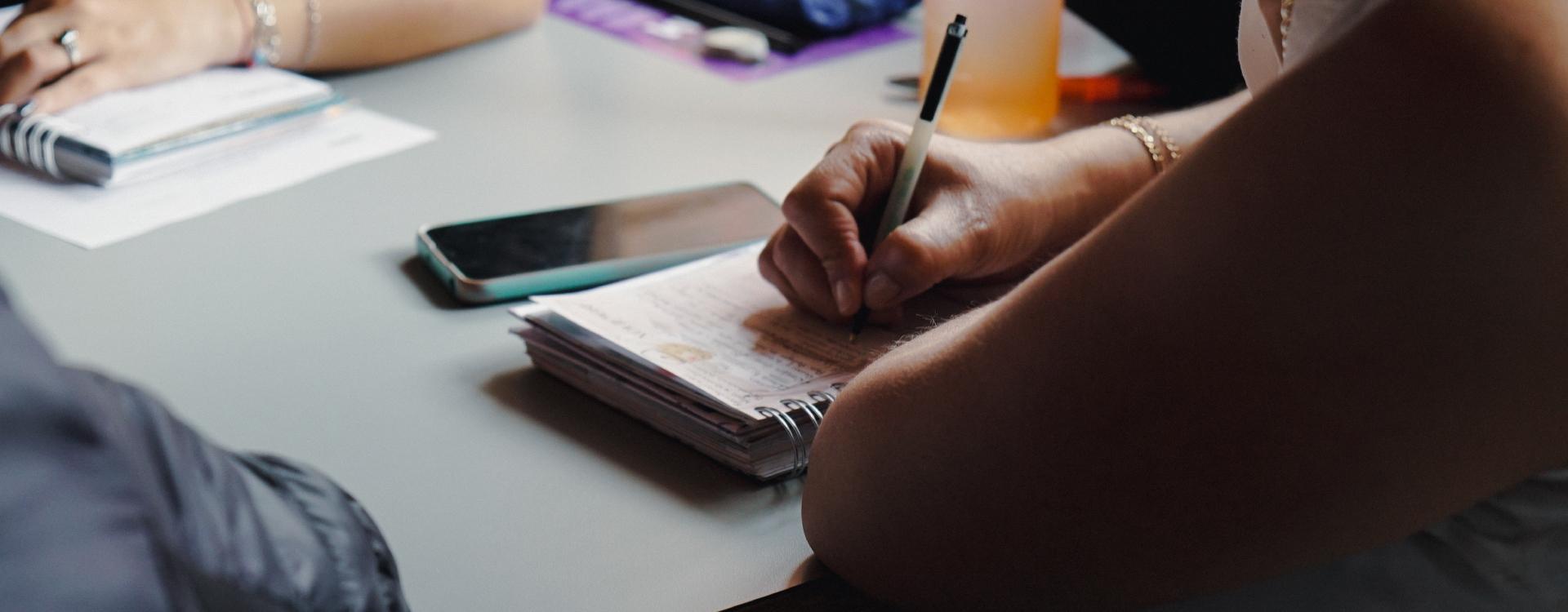 Manos de mujer mayor escribiendo en libreta